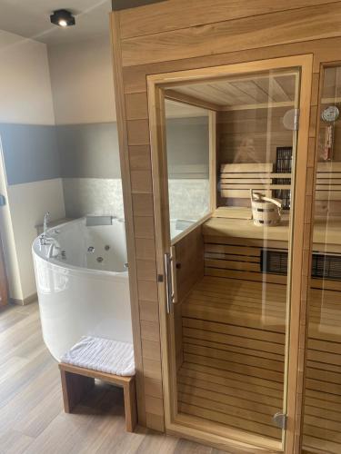 uma casa de banho com uma banheira e um armário de madeira em Turistična Kmetija Pungračič em Zavrč