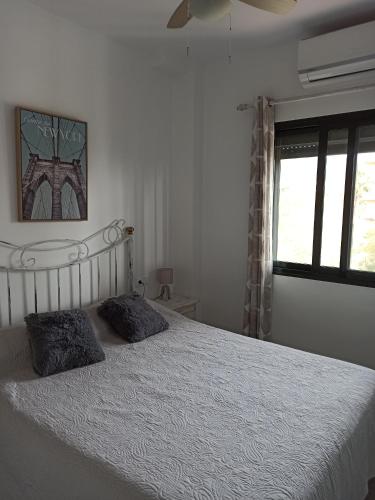 a bedroom with a bed with two pillows on it at Playa Atlanterra, 1ª linea playa vistas al mar in Zahara de los Atunes