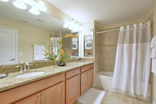 ein Badezimmer mit einem Waschbecken, einer Badewanne und einer Dusche in der Unterkunft Five Bedrooms TownHome with Pool 4849 in Kissimmee