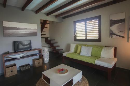 a living room with a couch and a tv at Flor da Mata in Pipa