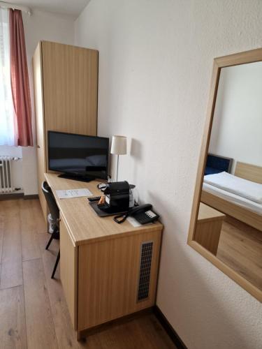 a room with a desk with a computer and a bed at Hotel Pegasus in Munich