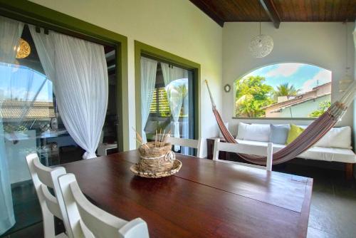 a dining room with a wooden table and chairs at Flor da Mata in Pipa