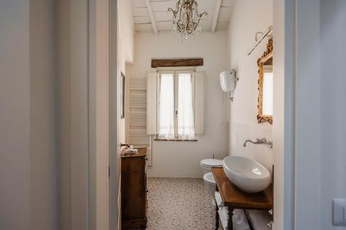 a bathroom with a sink and a toilet and a mirror at Locanda Mescoglia in Corciano