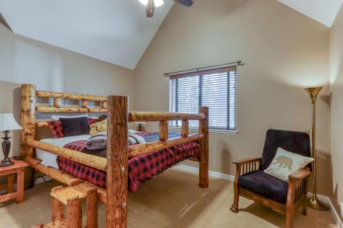 1 dormitorio con litera de madera y silla en Spacious Three Rivers Lodge✦Fenced .5 Acre✦Hot Tub, en Bend