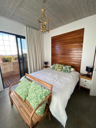 Un dormitorio con una cama grande con cabecero de madera. en CASA DA PITANGA, en Jardim do Mar
