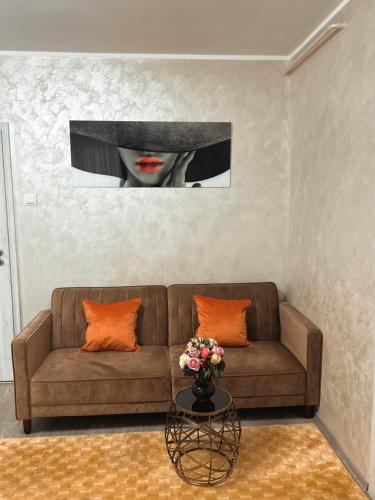 a living room with a couch and a vase of flowers at Central Apartament in Iaşi