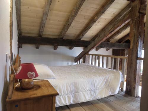 ein Schlafzimmer mit einem Bett und einer roten Lampe auf dem Tisch in der Unterkunft Chalet La Plagne jacuzzi vue top in Montchavin