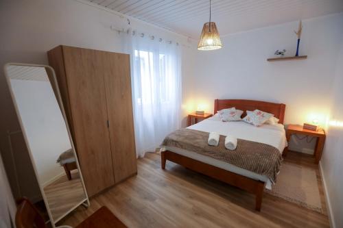 1 dormitorio con cama y espejo. en Tesouro do Atlântico, en Ponta Delgada