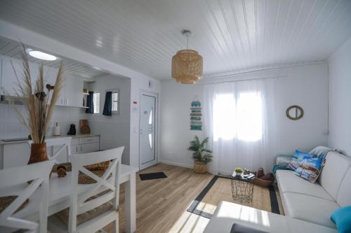 a living room with a white couch and a table at Tesouro do Atlântico in Ponta Delgada
