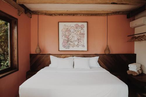 a bedroom with a white bed with orange walls at BOA BOA Bacalar in Bacalar