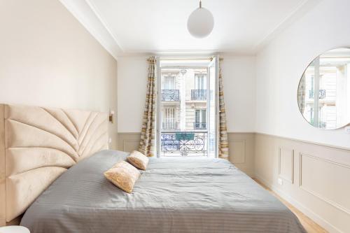 Bett in einem Zimmer mit Fenster in der Unterkunft SUITE RAPHAEL Tour Eiffel in Paris