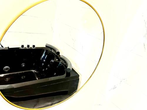 a mirror with a black sink in a bathroom at Duke and Duchess Apartments and Rooms - Private in Room Hot Tub Suites in London
