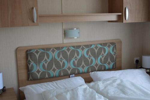 a bedroom with a bed with a wooden head board at Bobby's Bolthole in Heysham