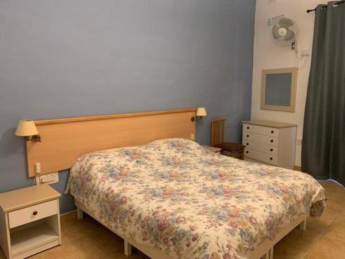 um quarto com uma cama com colcha floral em GELMIF Apartments em Vittoriosa