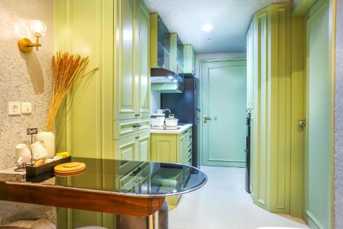 - une cuisine avec un comptoir en verre dans une pièce dans l'établissement Apartment Embarcadero Bintaro Suites by Novie Mckenzie, à Pondokaren