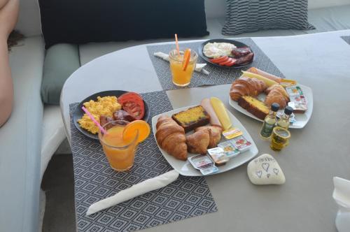 a table topped with plates of food and drinks at Flaskos Luxury Suites in Agios Stefanos