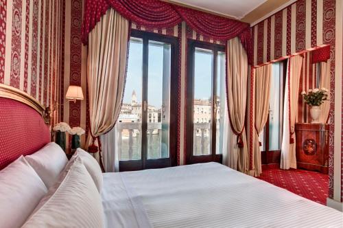 a bedroom with a large bed with a window at Sina Palazzo Sant'Angelo in Venice
