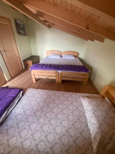 two beds in a room with purple sheets at Villa 80 Kodra e Diellit in Tetovo