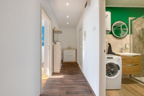 a laundry room with a washer and dryer and green walls at Apartment Niksa in Pula