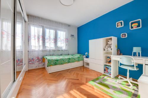 a blue room with a bed and a chair at Apartment Niksa in Pula
