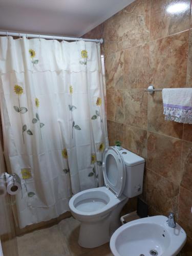 a bathroom with a toilet and a shower curtain at La Soñada II in Alta Gracia