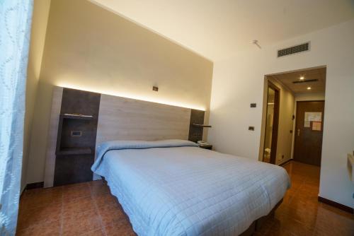 a bedroom with a large white bed in a room at Hotel Lago Bin in Rocchetta Nervina