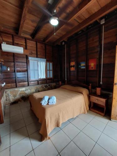a bedroom with a bed with two towels on it at Sunset Bay B&B in Corn Island