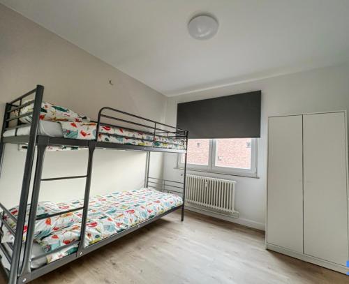 a bedroom with two bunk beds and a window at tirou 5 centre Brussels-charleroi-airport in Charleroi