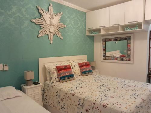 a bedroom with a bed and a snowflake clock on the wall at Linda Casa Condomínio Maresias in Maresias