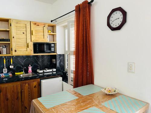 a kitchen with a table and a clock on the wall at Catherine Suites in Willemstad