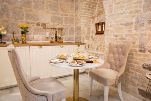 a table with a plate of food and two chairs at Guest House Paradise in Split