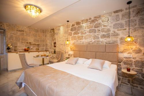 una camera con un grande letto e un muro di pietra di Guest House Paradise a Spalato (Split)