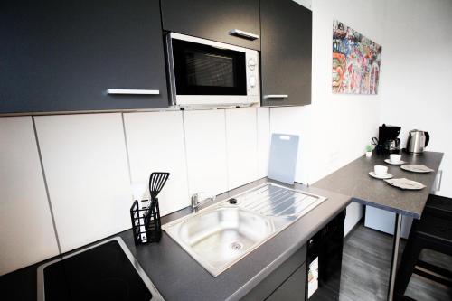 a kitchen with a sink and a microwave at SH Team Lodges 4 Apartments für max 19 Personen l Monteure l Messe l Business in Duisburg