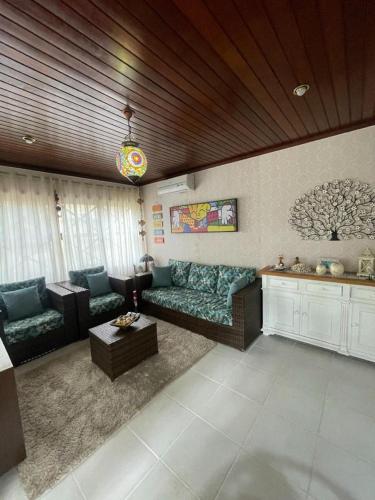 a living room with a couch and a table at Linda Casa Condomínio Maresias in Maresias