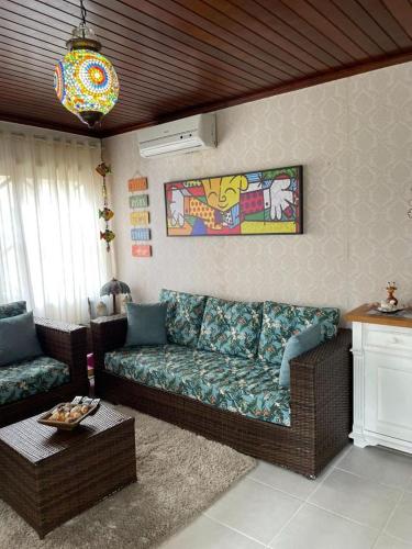 a living room with a couch and a table at Linda Casa Condomínio Maresias in Maresias