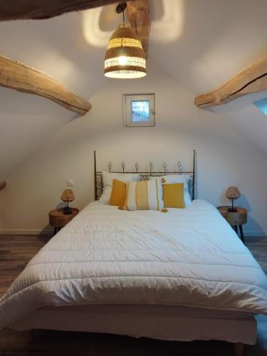 une chambre avec un grand lit avec des oreillers jaunes dans l'établissement Baia, Une charmante maison avec jardin, à Flagy