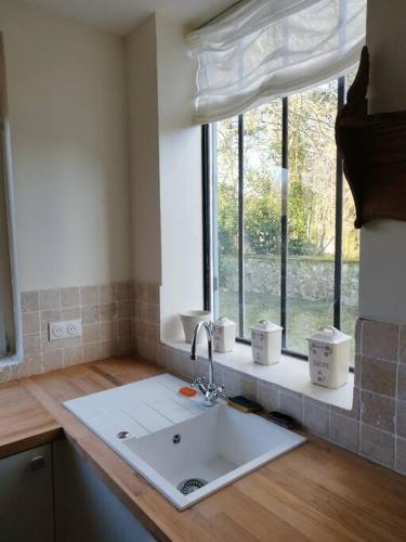 un comptoir de cuisine avec un évier et une fenêtre dans l'établissement Baia, Une charmante maison avec jardin, à Flagy