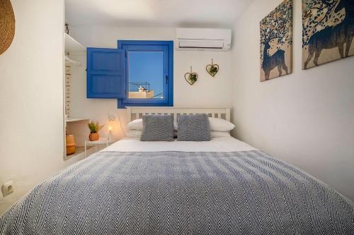 a bedroom with a large bed with blue accents at Casa Corbeto 43 in Cómpeta