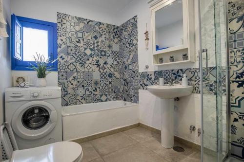 a bathroom with a washing machine and a sink at Casa Corbeto 43 in Cómpeta