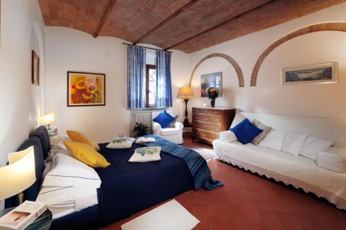 a bedroom with a bed and a couch in a room at Casa Vacanze Rondini Blu in Montespertoli