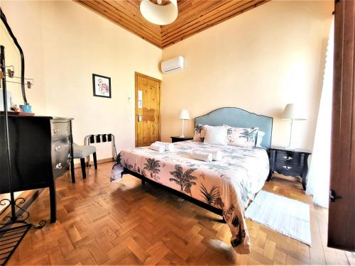 um quarto com uma cama e piso em madeira em Sunlight House em Faro