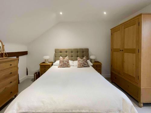 a bedroom with a large white bed with two pillows at Immaculate barn annexe close to Stansted Airport in Great Dunmow