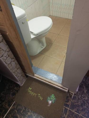 a bathroom with a toilet and a sign that says happy thee at Gallaghers city ( YameHome ) in Bangangté