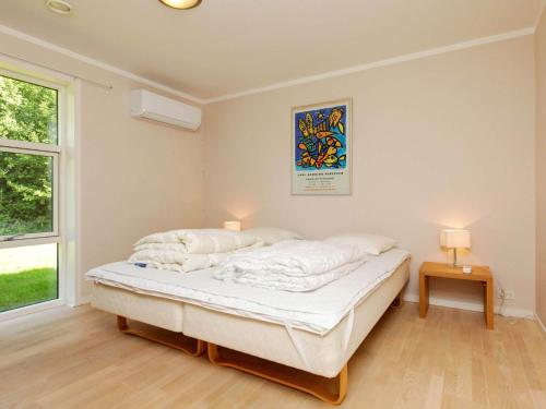 a bedroom with a bed and two lamps and a window at Three-Bedroom Holiday home in Gilleleje 14 in Gilleleje