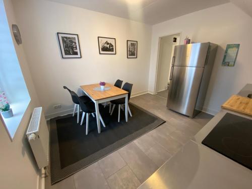 a kitchen with a table and chairs and a refrigerator at Apartment/Wohnung Netflix+Prime in Krefeld