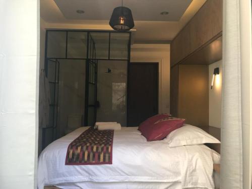 a bedroom with a large white bed with red pillows at CASA LALIQUE in Mexico City