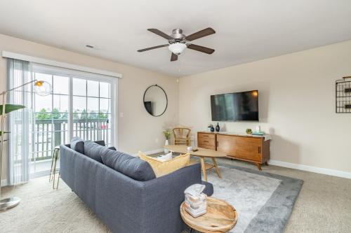 a living room with a blue couch and a tv at ConTemporary Stay in Central Peoria in Peoria