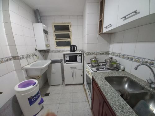 eine kleine Küche mit einer Spüle und einem Herd Top-Backofen in der Unterkunft LA SAN JUAN en Zona Norte in San Miguel de Tucumán