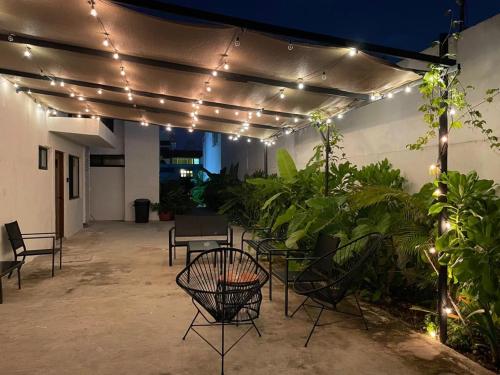 a patio with lights and chairs and plants at Aldeazul by Andiani Travel in Cancún