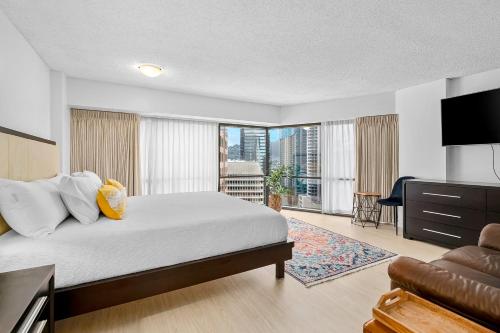 a hotel room with a bed and a television at Hale Kekai on Bishop 2412 - 30-Day Minimum in Honolulu